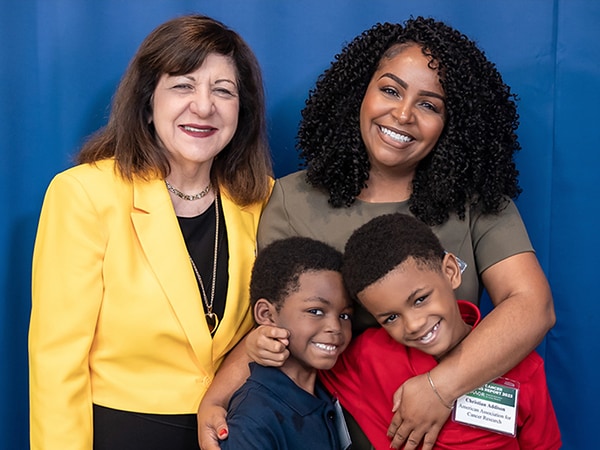 AACR CEO Margaret Foti with cancer survivor Cayden Addison, his mother Courtney, and his brother Christian